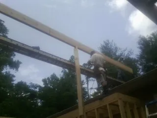 Carpenter setting a ridge beam over a new addition frame — Ice Dam Removal by Roofing Brothers in Windham